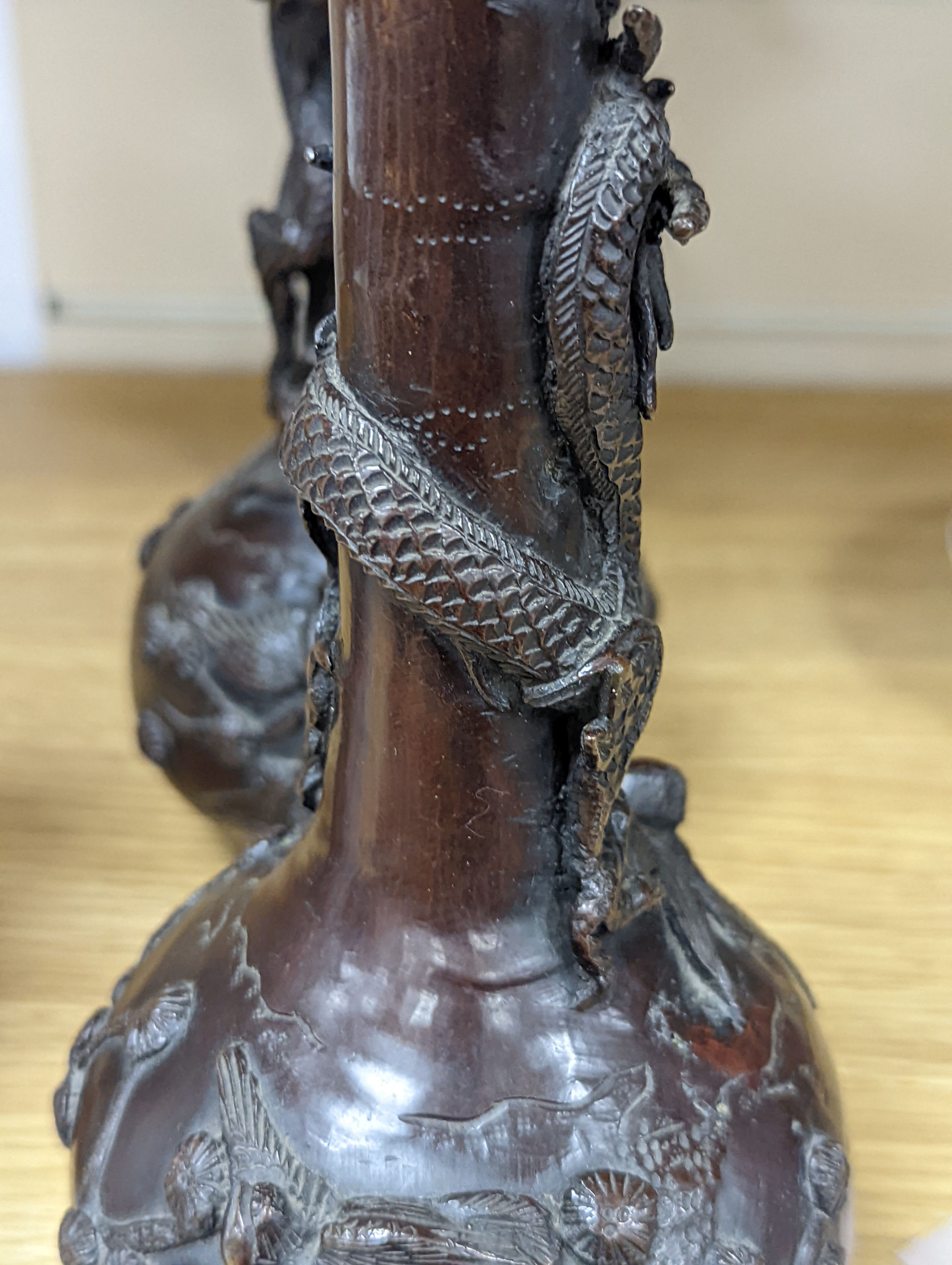 A pair of Japanese Meiji period bronze ‘dragon’ bottle vases and another, 21cm